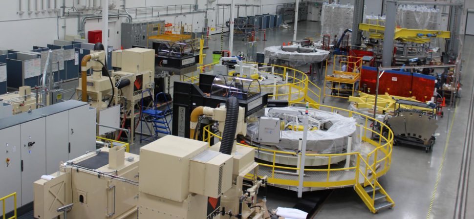 A partial view of the General Atomics module fabrication line, with two winding station tables visible behind a yellow rail. Photo: GA