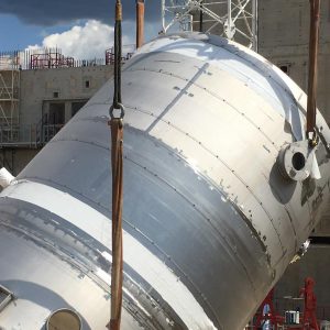A 61,000 gallon drain tank, part of the US-provided tokamak cooling water system, is lifted into the tokamak complex for installation in the basement.