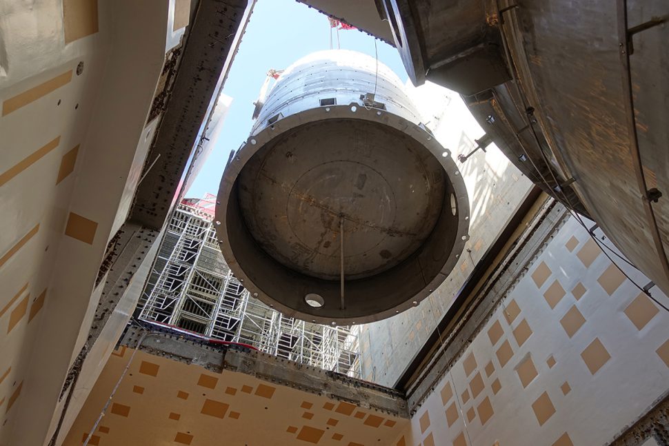 A "normal" 61,000 gallon drain tank is lowered into the B2 level of the tokamak complex. The embedded plates in the basement are visible on the walls.