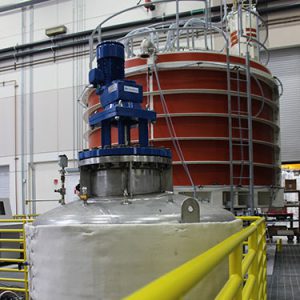The vacuum pressure impregnation station includes a resin reservoir (foreground) and a vacuum chamber that can hold a seven foot tall module. Photo:GA